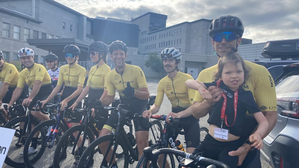 Men and women are on bicycles and pose for the camera. 