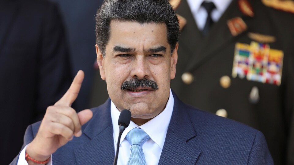 Le président du Venezuela, Nicolas Maduro, debout au micro alors qu'il prend la parole pendant une conférence de presse.