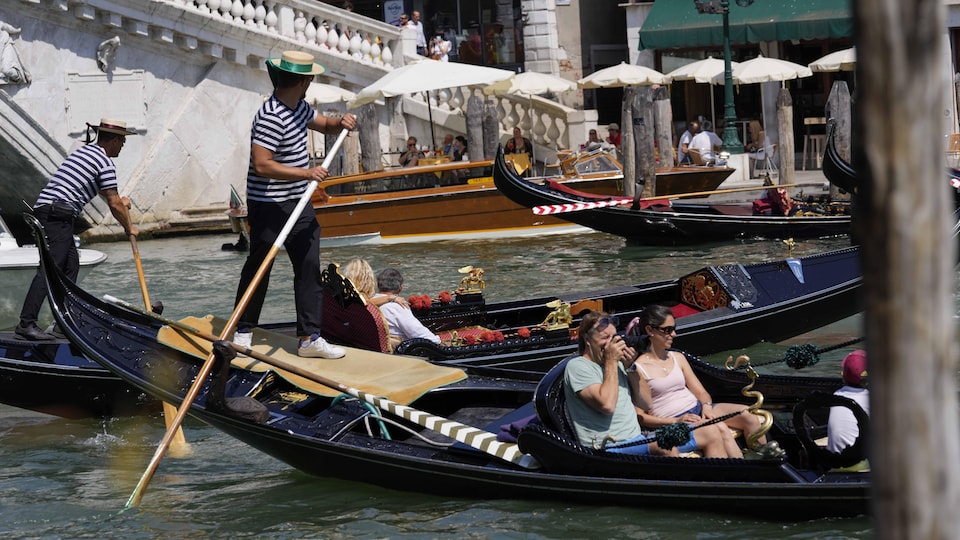 Des touristes en gondole dans un canal de Venise.