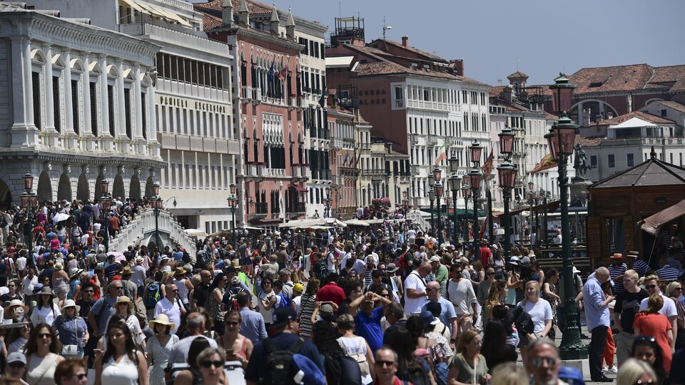Des centaines de touristes se promènent sur la place Saint-Marc, l'été.