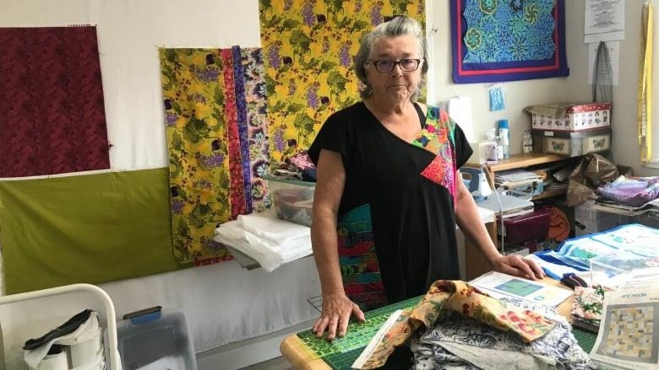 Verna Miller est dans son atelier, rempli de tissus.