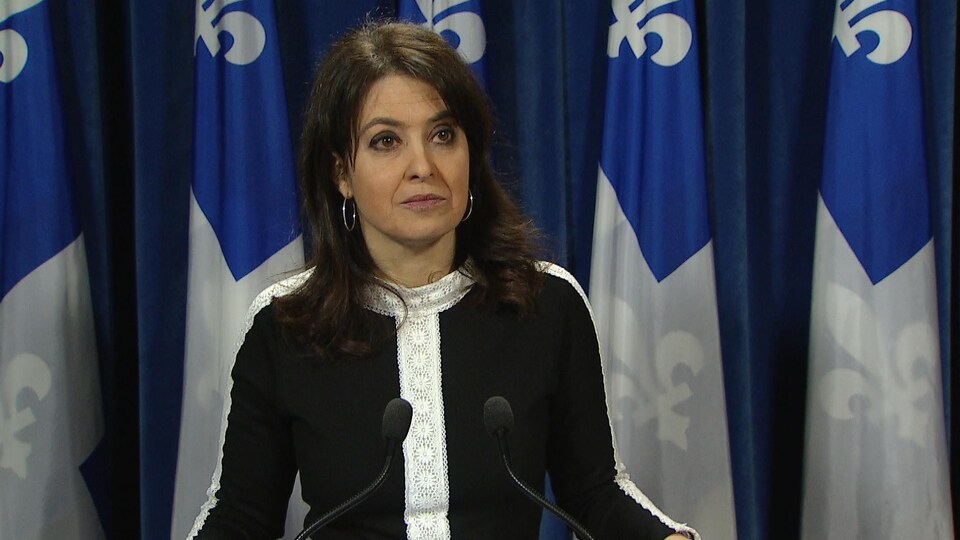 Véronique Hivon devant des drapeaux du Québec.