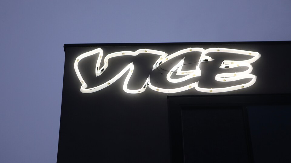 Le logo de Vice affiché la façade d'un immeuble noir, devant un ciel bleuté. 