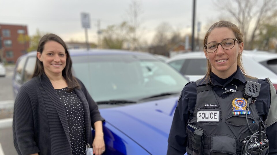 Les deux femmes sont côte à côte, devant une voiture.