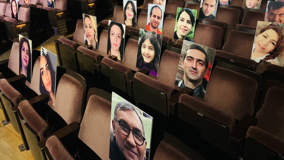 Des photographies des victimes de l'écrasement du vol PS-752 sont disposées sur les bancs d'une salle de spectacle.