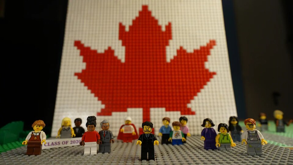 Des personnages Lego devant une plaque de Lego représentant le drapeau du Canada. Parmi les personnages : le premier ministre Justin Trudeau et un groupe de finissants.
