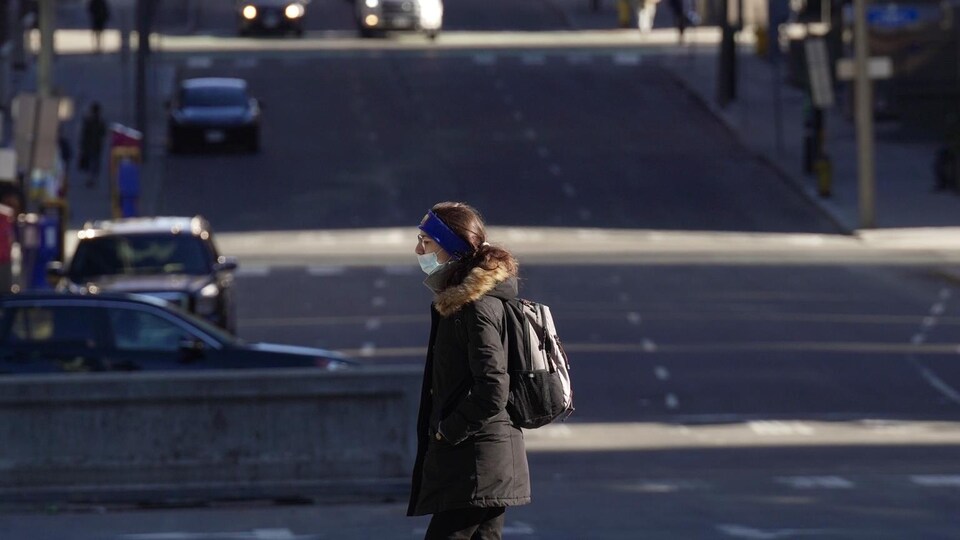 Une personne traverse à pied une rue du centre-ville d'Ottawa.