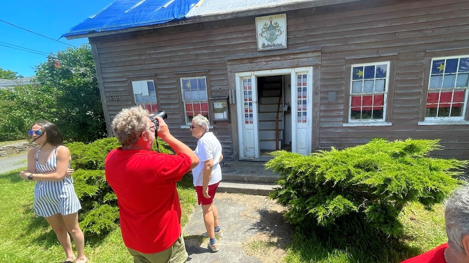 Des touristes admirent la Vieille Maison de Meteghan.