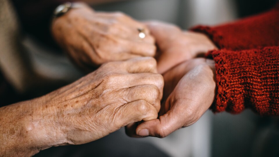 Deux personnes se tiennent les mains en signe de soutien