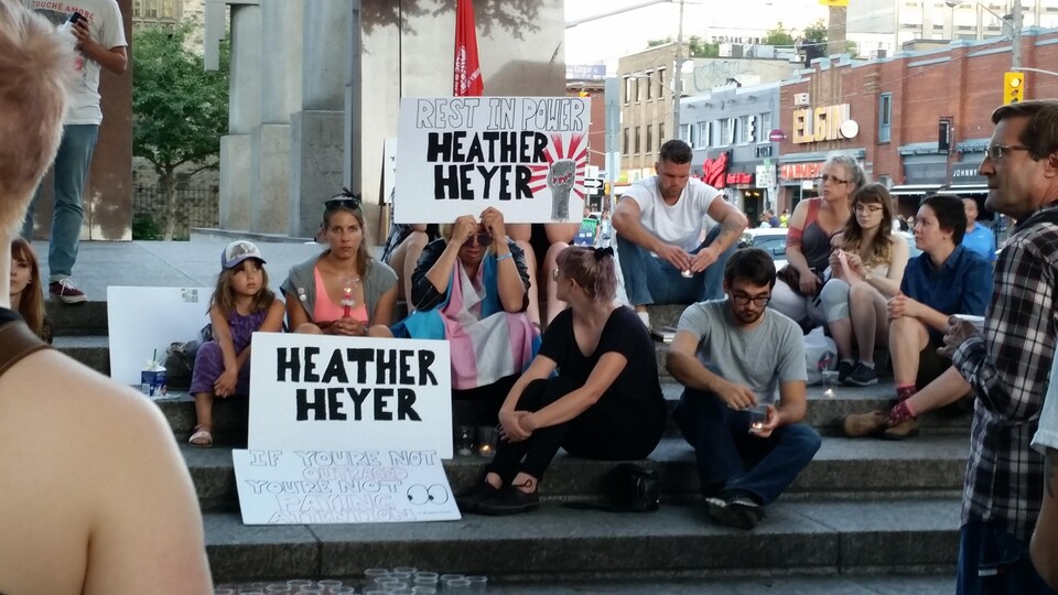 Des manifestants assis avec des pancartes mentionnant leur soutien à Heather Heyer, mort le 14 août à Charlottesville.