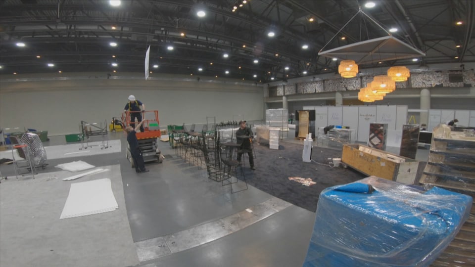 Des travailleurs dans la salle principale du Centre des congrès de Québec.