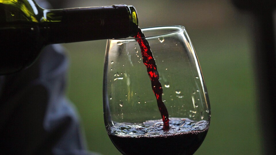 Du vin est versé d'une bouteille à un verre.