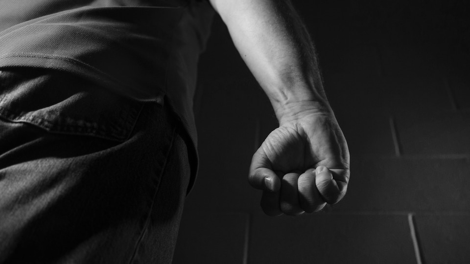 Un homme avance, le poing menaçant