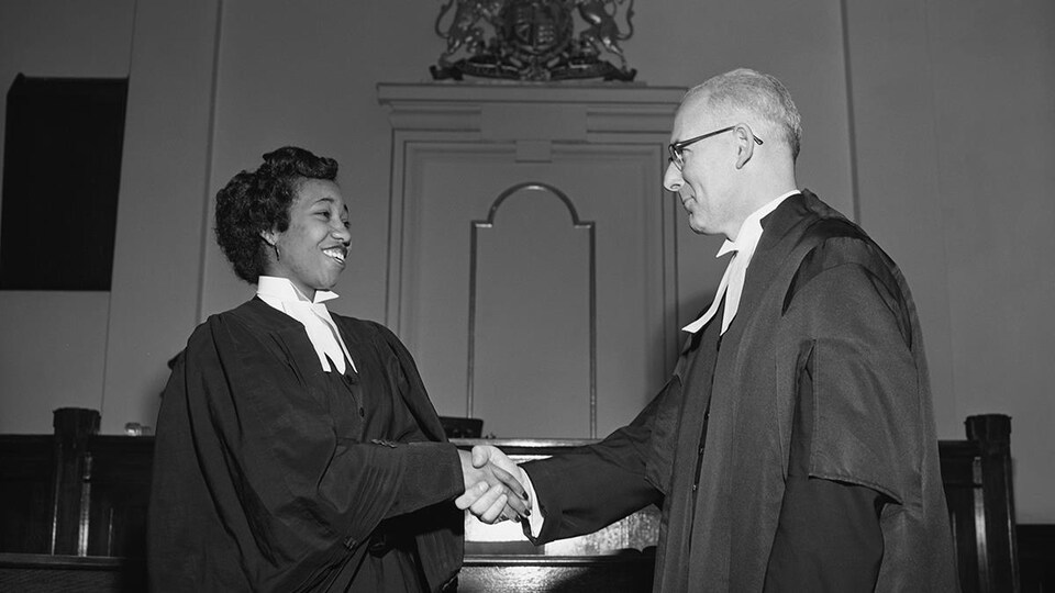 Violet King, vêtue d'une toge, serre la main d'un autre avocat.