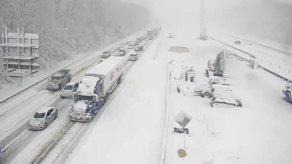 Des voitures englouties par la neige sur l'autoroute.