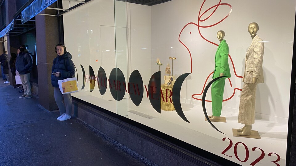 A clothing store window with a rabbit illustration in the background and happy Lunar New Year wishes on the window display.
