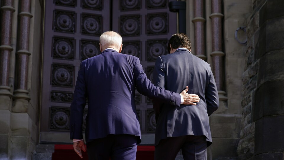 Deux hommes montent des escaliers. 