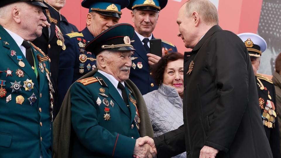 Vladimir Putin shook hands with an elderly veteran who wore several military medals.