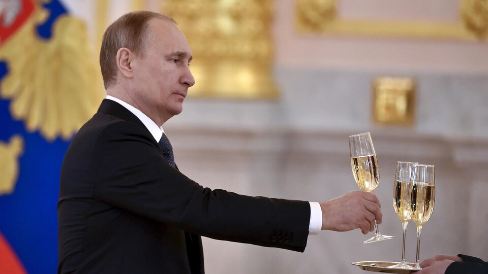 Vladimir Poutine se sert un verre de champagne.