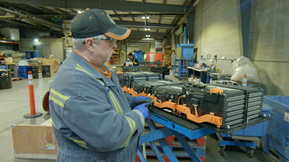 Un homme se met au travail dans une usine de recyclage.