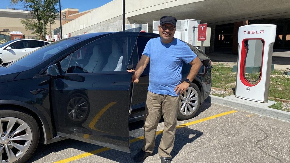 Arfen Ahmed, un Ontarien de passage à Winnipeg, recharge sa voiture électrique au centre commercial Polo Park, le 9 août 2022. 