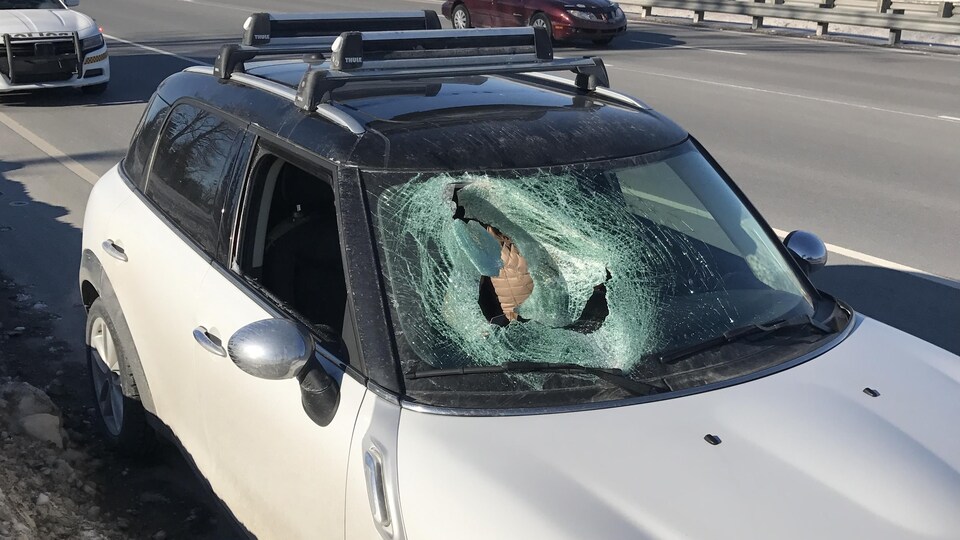 Le pare-brise de cette voiture a été lourdement endommagé par un morceau de glace en provenance d'un autre véhicule.