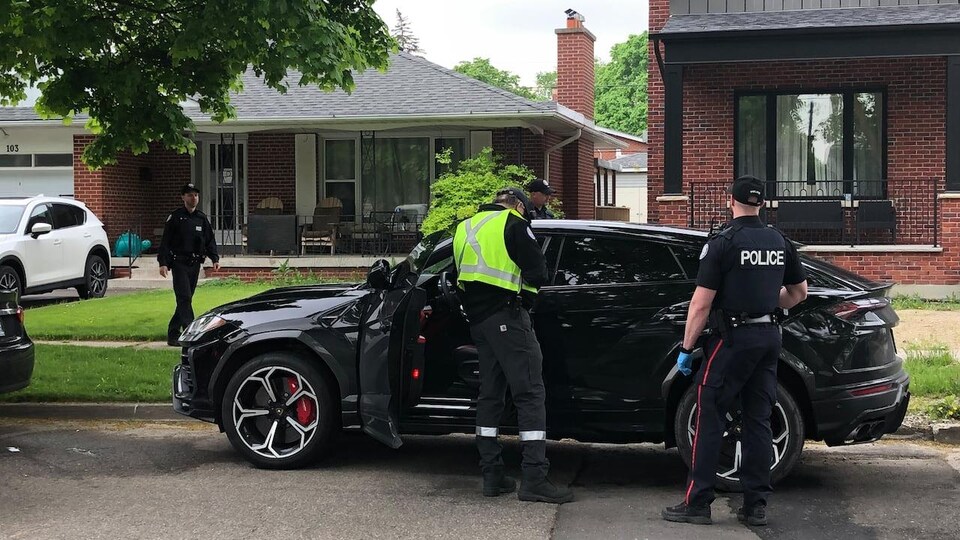 Deux policier devant une voiture.