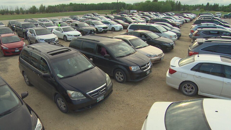 Des centaines de voitures sont stationnées sur un grand terrain.