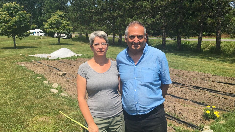 Lyne Fortin et Maher Hanna devant leur champ d'ail désormais vide.