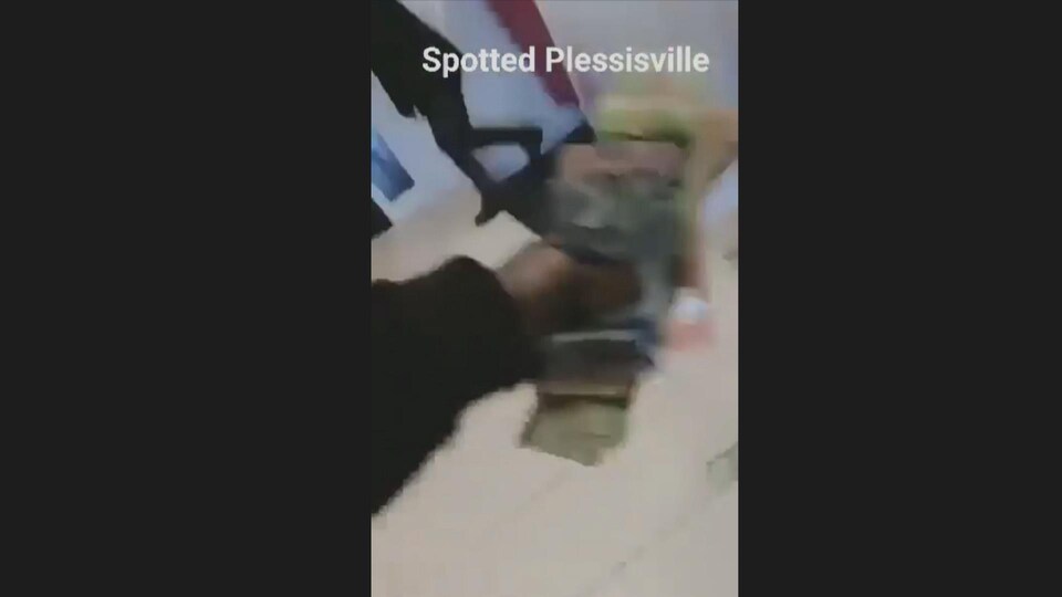 Une liasse de billets dans la main du cambrioleur.
