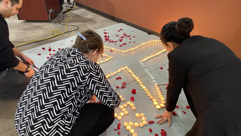 Des bougies placées pour former un avion, en souvenir du vol PS752, à l'intérieur de la chapelle de l'Université de la Saskatchewan. 