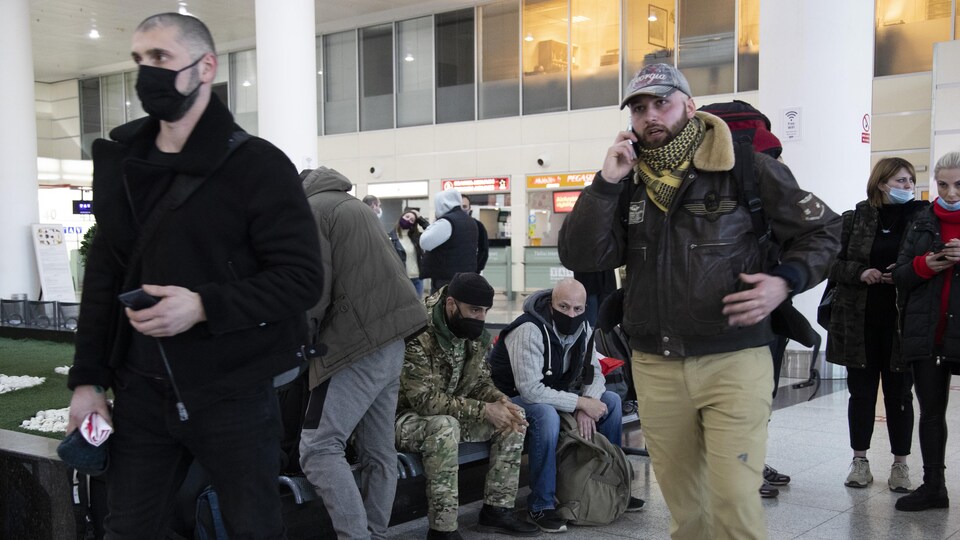 Des hommes et des femmes rassemblées dans une salle