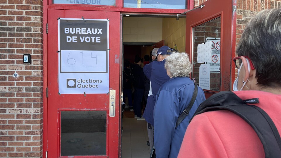 Des personnes font la file devant un bureau de vote de l'Outaouais.