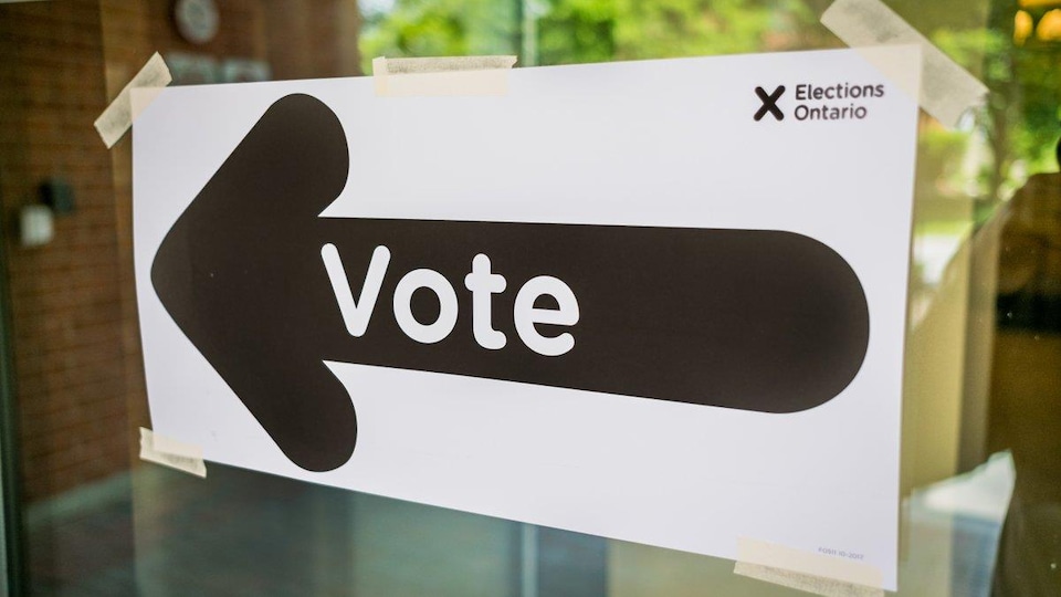 Une enseigne avec une flèche qui indique où aller voter.