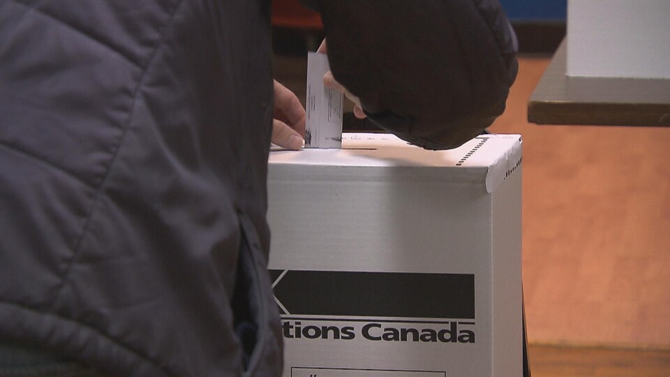 Un électeur dépose son bulletin de vote.