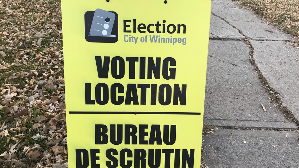 Un panneau jaune indiquant un bureau de vote à Winnipeg.