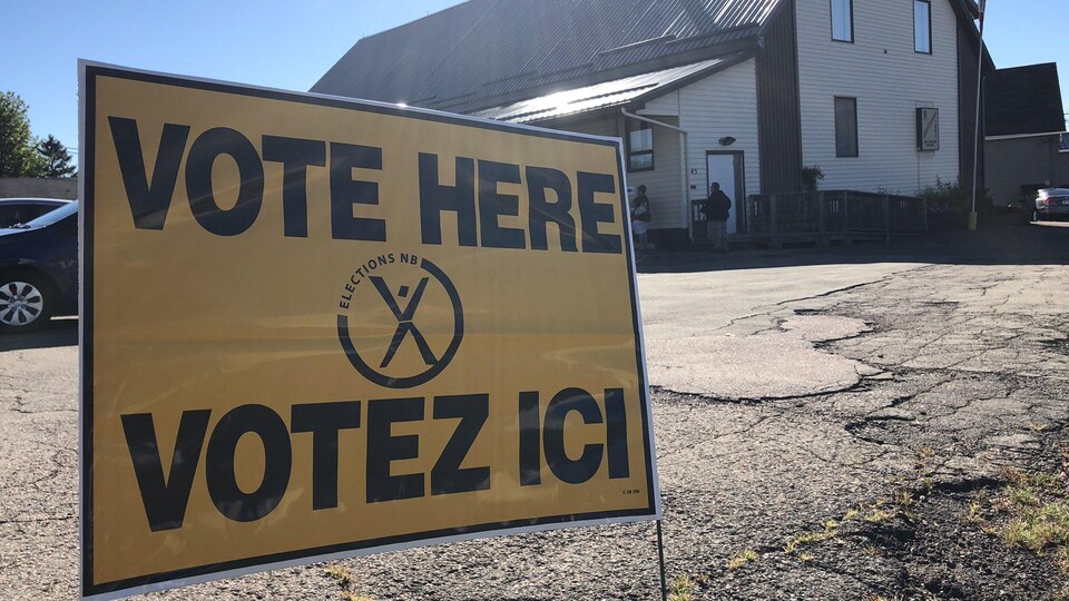 Une pancarte sur le sol sur lequel est écrit «VOTE HERE - VOTEZ ICI »