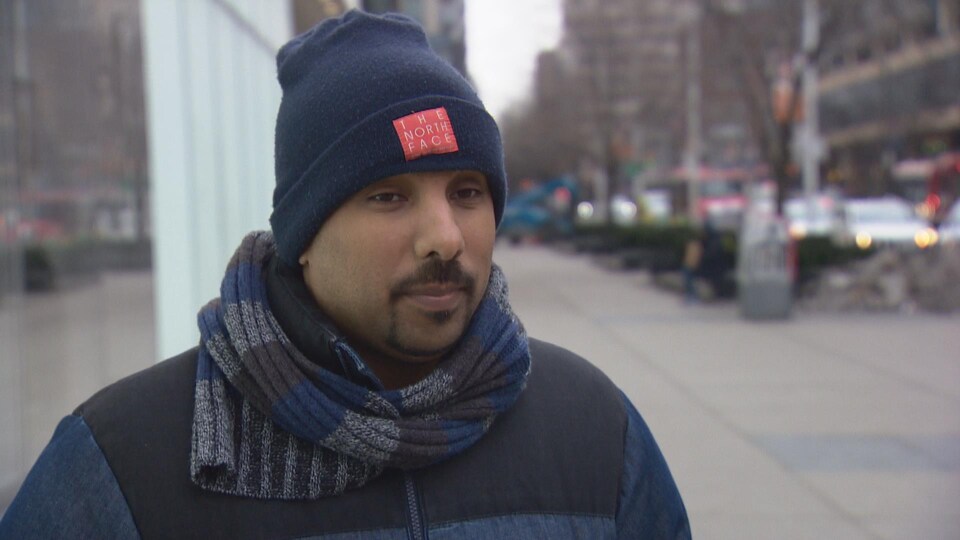 Un homme portant une tuque à l'extérieur, au centre-ville de Toronto.