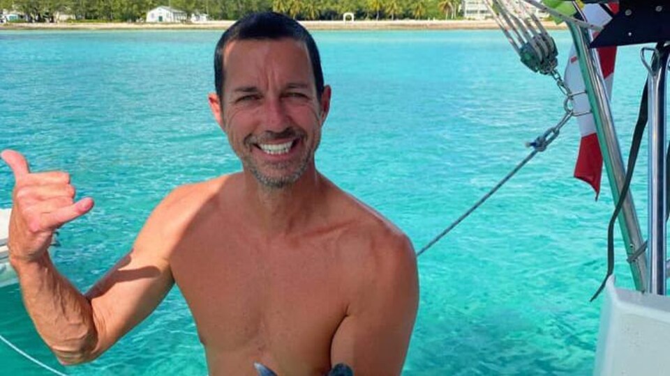 A man shows a fish he has just caught.