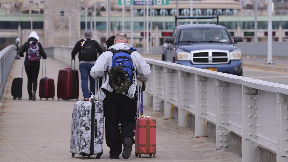 Des voyageurs traversent le pont Rainbow à Niagara Falls pour rentrer au Canada.