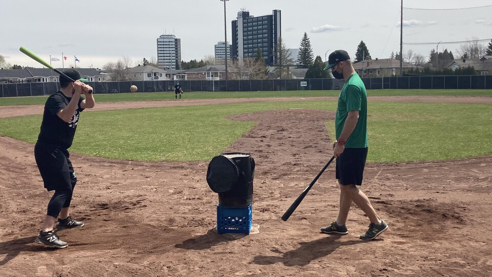 Des hommes pratiquent au baseball.