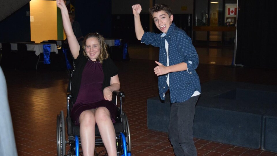 Une élève dans un fauteuil roulant, dansant avec un élève debout lors du mini-bal des finissants.