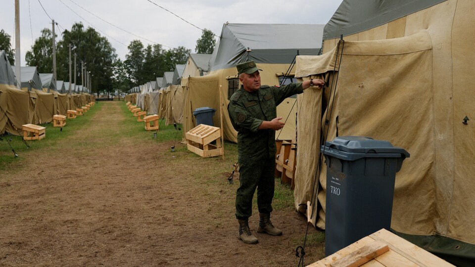 L'officier du ministère bélarusse de la Défense, Leonid Kasinsky, montre aux journalistes un camp de tentes qui, selon le ministère, a été installé pour des exercices dans une base militaire désaffectée près du village de Tsel.