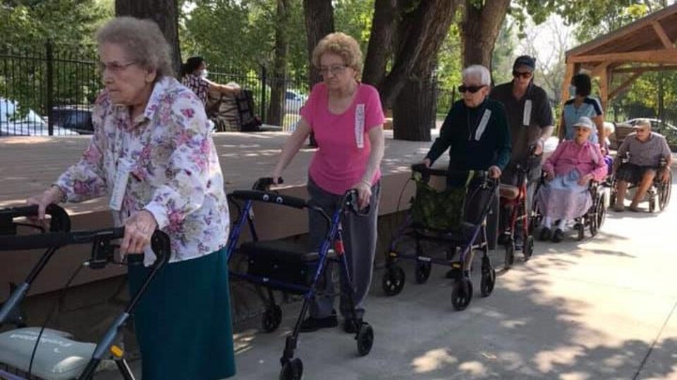 Des personnes âgées marchent en se suivant.