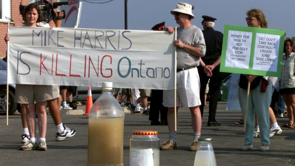 Des protestataires attendent Mike Harris en 2001.