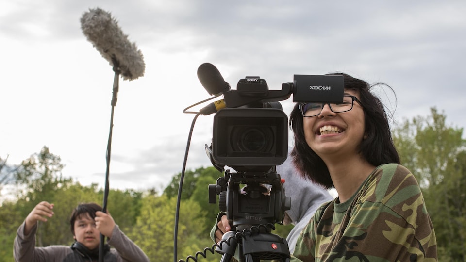 De jeunes Autochtones s'occupent respectivement du son et de la caméra lors d'un tournage.