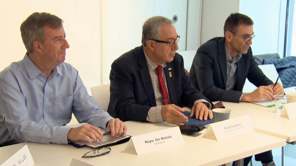 Le maire d'Ottawa, Jim Watson, accompagné du conseiller Eli El-Chantiry et de Pierre Poirier lors d'une réunion.