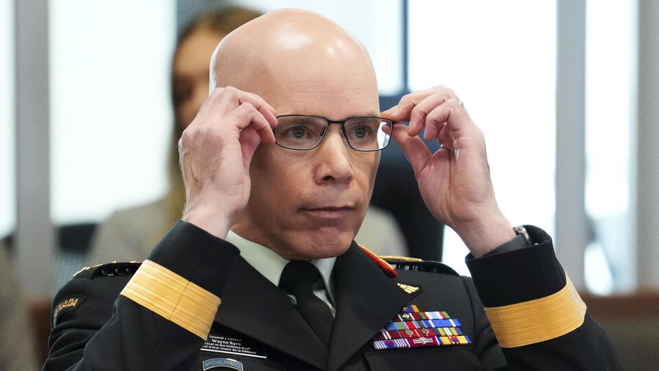 Gros plan du chef d'état-major de la Défense Wayne Eyre qui ajuste ses lunettes.