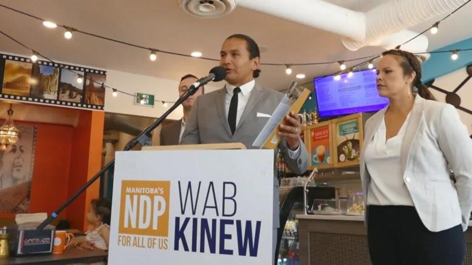 Wab Kinew sur un podium.