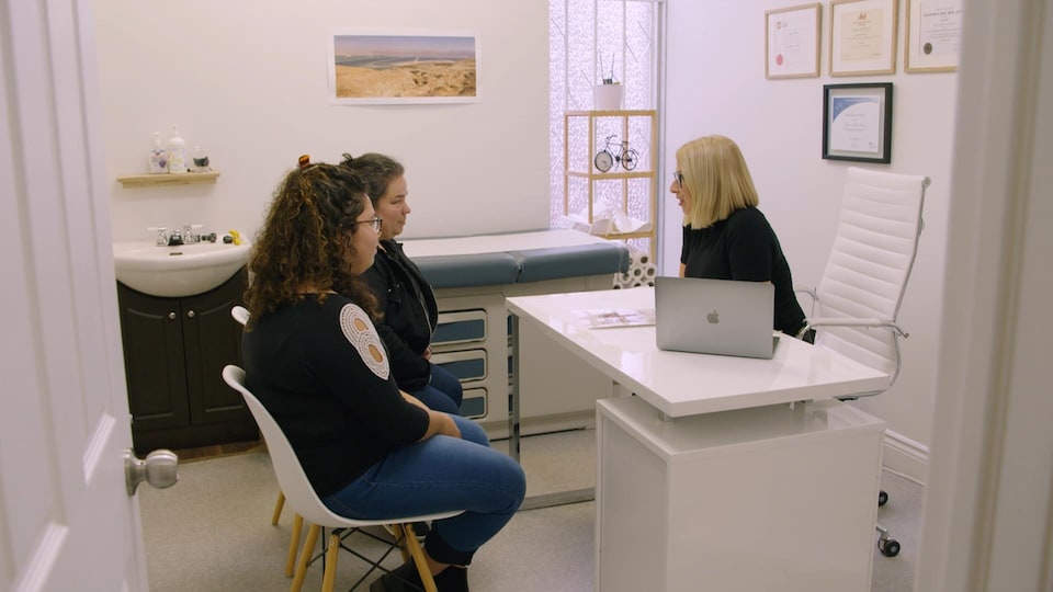 Les trois femmes discutent dans le bureau de la médecin.